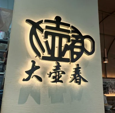 Dahuchun’s illuminated Chinese shop sign and teapot emblem in Shanghai