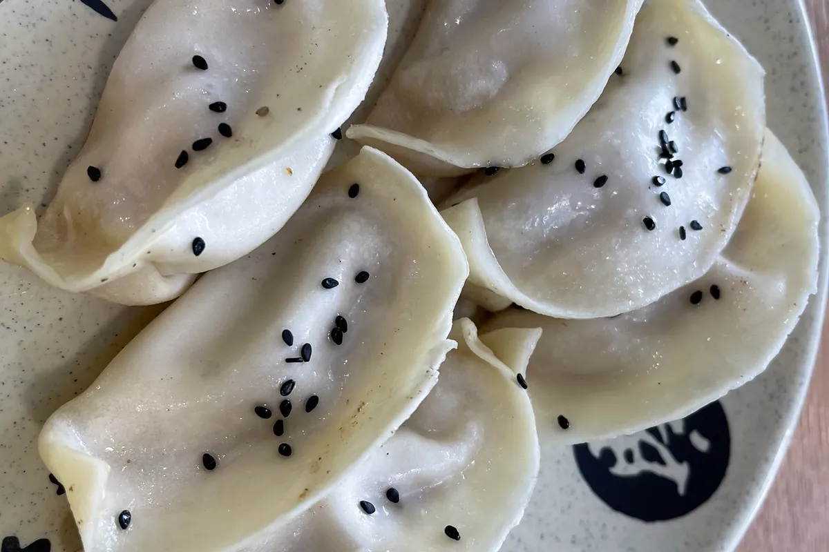 A close-up of guotie fresh from the pan, their fried bases crackling