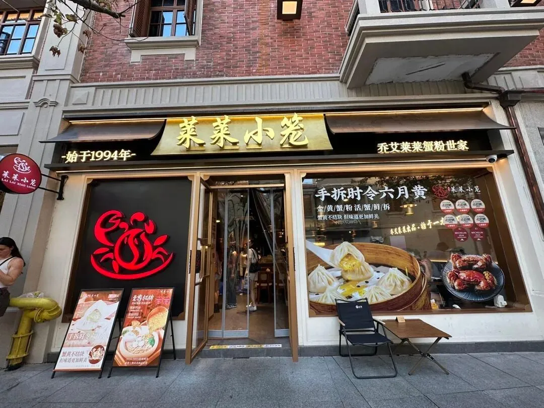Lailai’s street entrance with gold Chinese lettering and pictured dishes beside the door