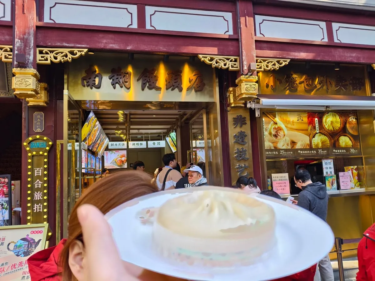Nanxiang’s traditional red and gold storefront, with a large soup dumpling held in front