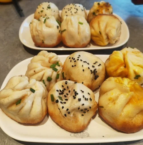 Shengjian buns with golden pan-fried bottoms, sesame and scallions at Dahuchun