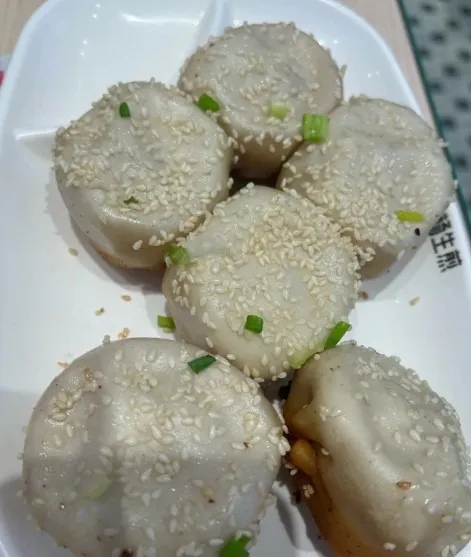 Xiaoyang shengjian bao topped with white sesame and scallions