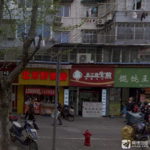 A Wujiang Road shengjian shopfront with steamers behind a glass counter